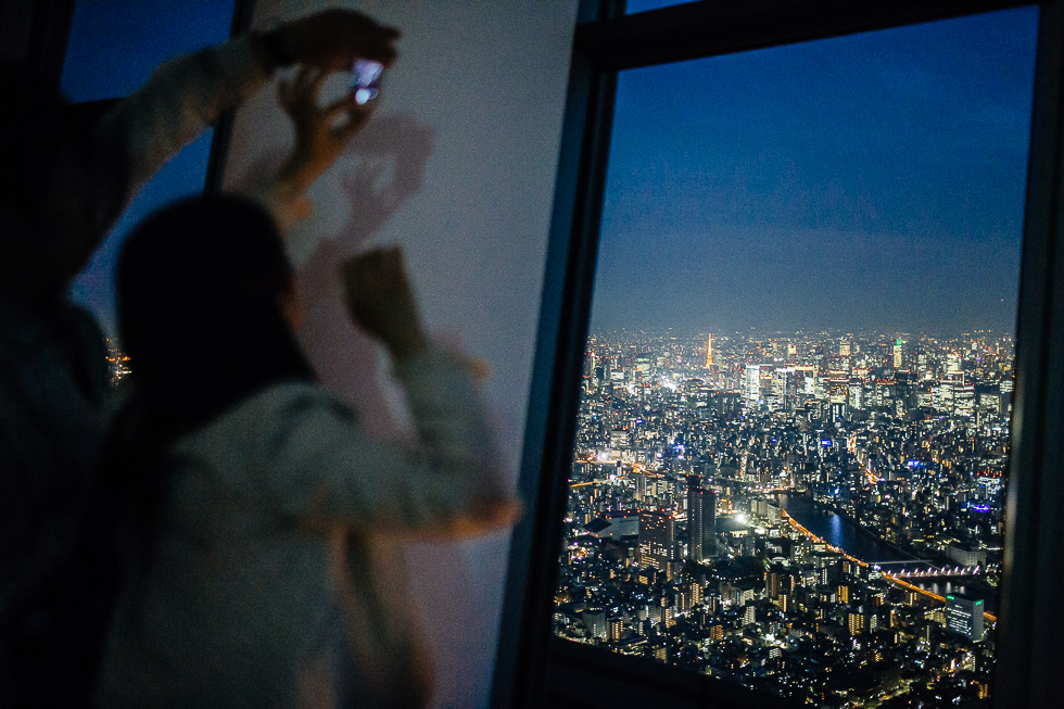 Des touristes prennent une photo de Tokyo depuis l'observatoire public (à 450 mètres) de la tour SkyTree (634 mètres, la deuxième plus haute au monde) le 25 avril 2014. 