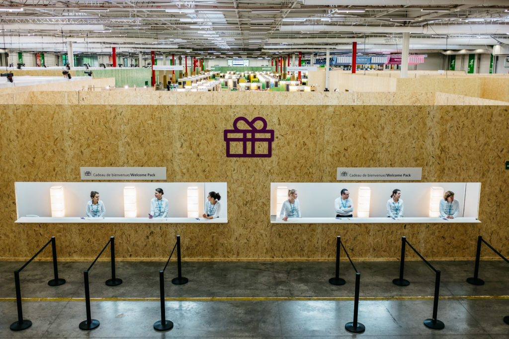 Le Bourget. 29 novembre 2015 Des hôtesses d’accueil attendent les premiers des 40 000 participants à la COP21 pour leur remettre un cadeau de bienvenue (un sac recyclé et une gourde réutilisable). Plusieurs semaines de travaux ont été nécessaires pour transformer le parc des expositions en une ville complète et écologique.