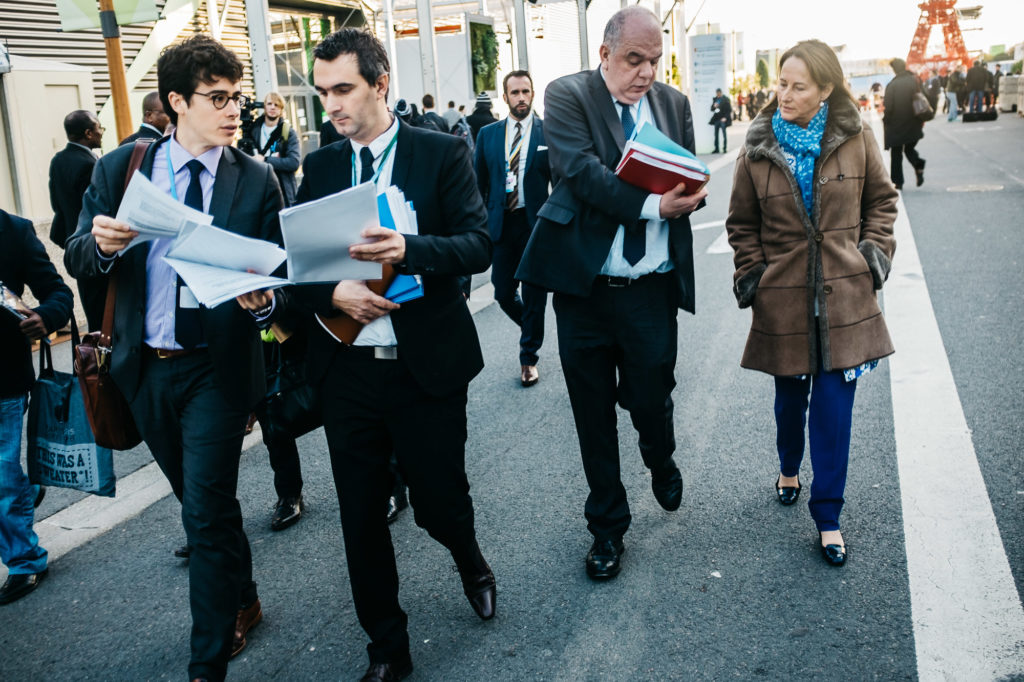 Le Bourget. 7 décembre. Début de la seconde semaine de COP21 pour Ségolène Royal, qui se fait briefer par ses conseillers entre deux discours. Elle enchaîne les prises de paroles publiques (jusqu'à 10 par jours) sur une variété de sujets.