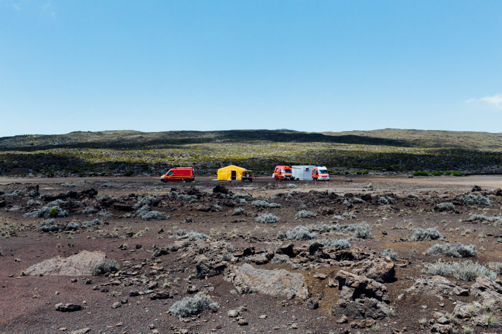 Des véhicules de la protection civile sont stationnées sur la plaine des sables dont une route mène au volcan le Piton de la Fournaise en fin d'éruption le 27 février 2017.