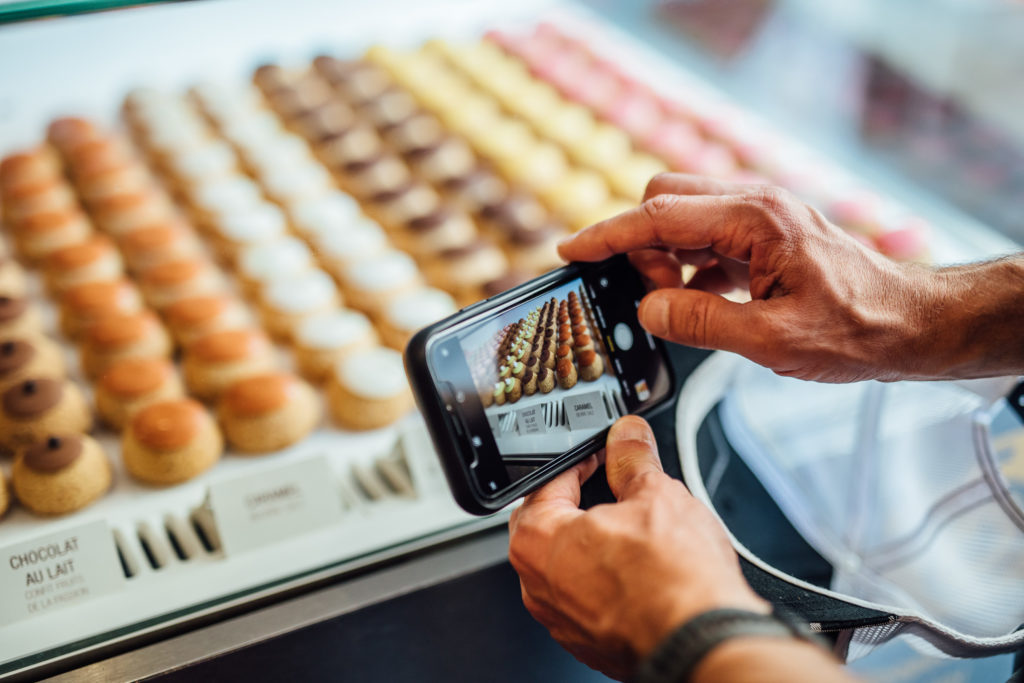 Get to know the Parisian neighborhood of Le Marais on a food walking tour with a guide who introduces you to local food vendors and artisans.
A tourist is taking a picture of small cakes in Popelini shop, Paris, on July 23th, 2019.