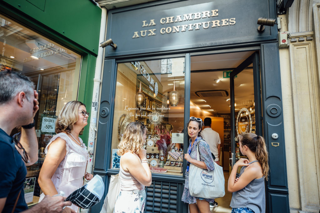 Get to know the Parisian neighborhood of Le Marais on a food walking tour with a guide who introduces you to local food vendors and artisans.
Tour guide and tourists in front La Chambre aux confitures, jam shop, Paris, on July 23th, 2019.