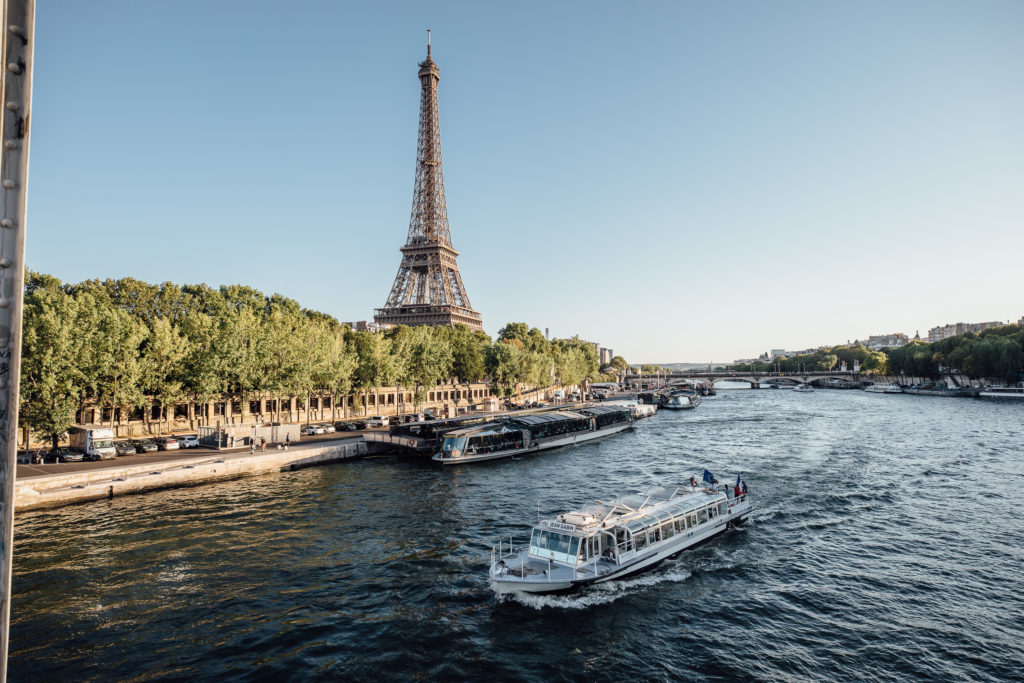 See the major sights of Paris from the water on a hop-on hop-off Seine boat cruise. 
Batobus on the Seine river with Eiffel tower on the background, Paris, on July 29th, 2019.